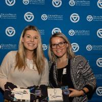 two alumni hold up their gifts on giving tuesday